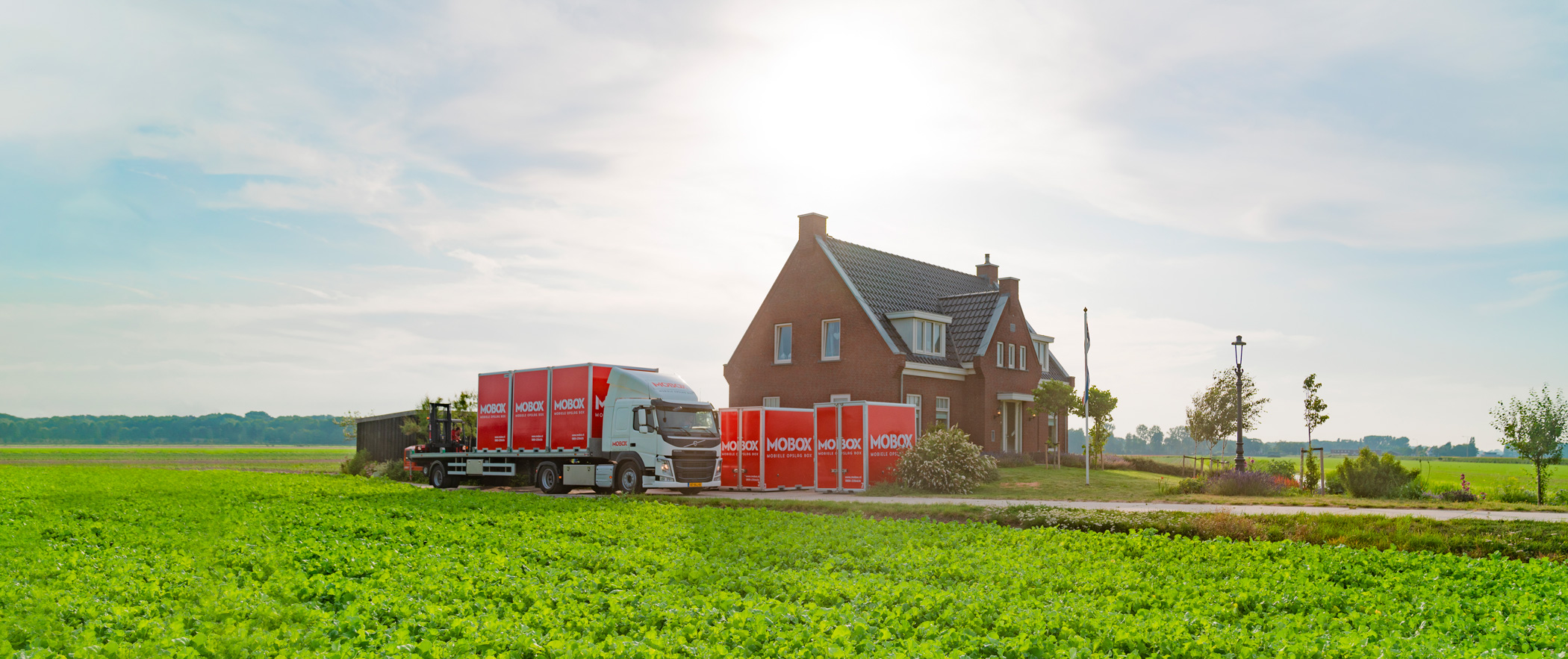 Mobox vrachtwagen laadt verhuiscontainer uit bij huis